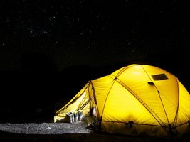 Beleuchtetes gelbes Campingzelt in der Dunkelheit