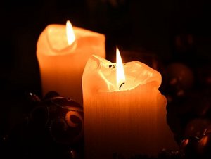 Zwei Kerzen leuchten in der Dunkelheit