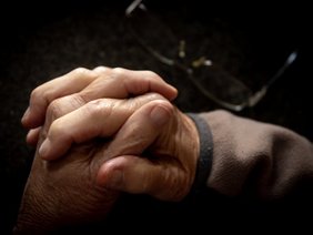 Ineinander gefaltete Hände eines älteren Mannes