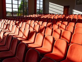 Mehrere Sitzreihen mit roten Theaterstühlen