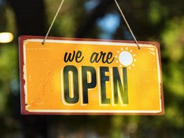 Ein Türschild mit der Aufschrift: We are open